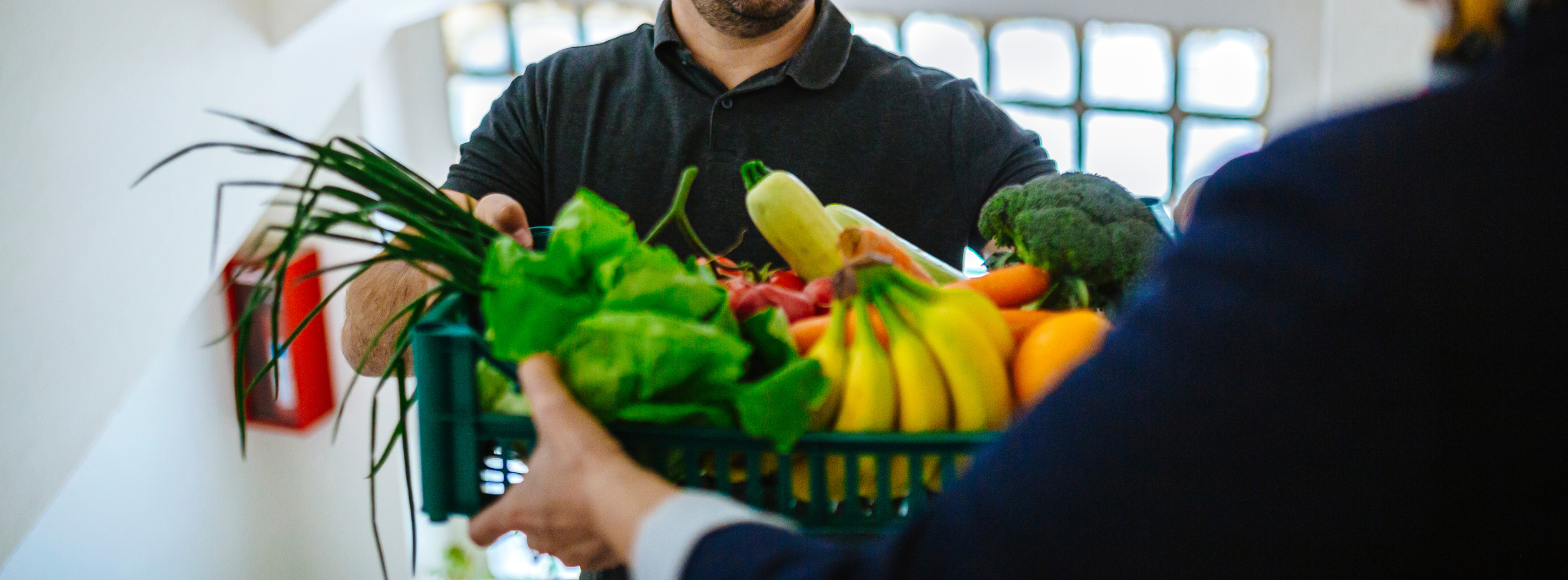 Intervenant livrant une caisse de fruits et légumes